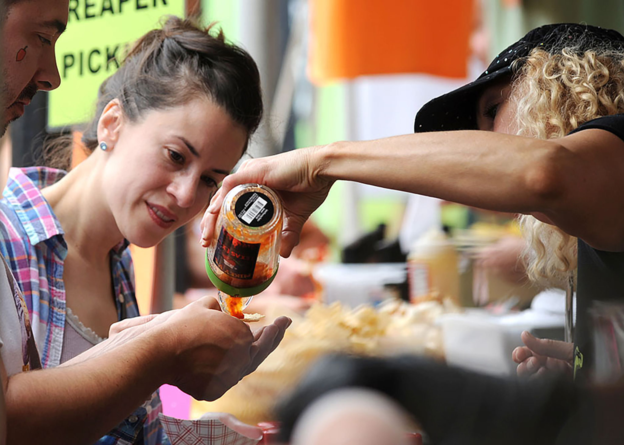 A woman sampling hot sauce