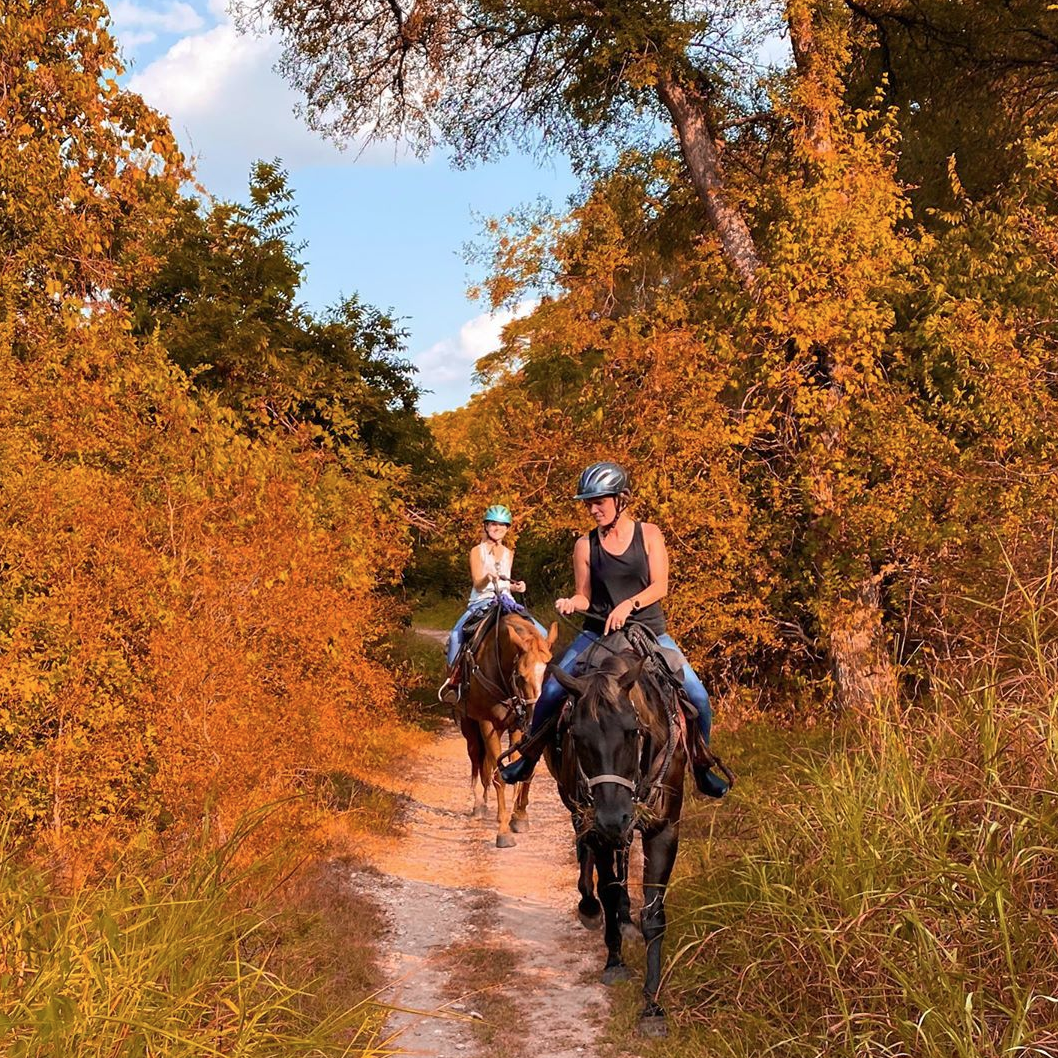 Two people horse riding