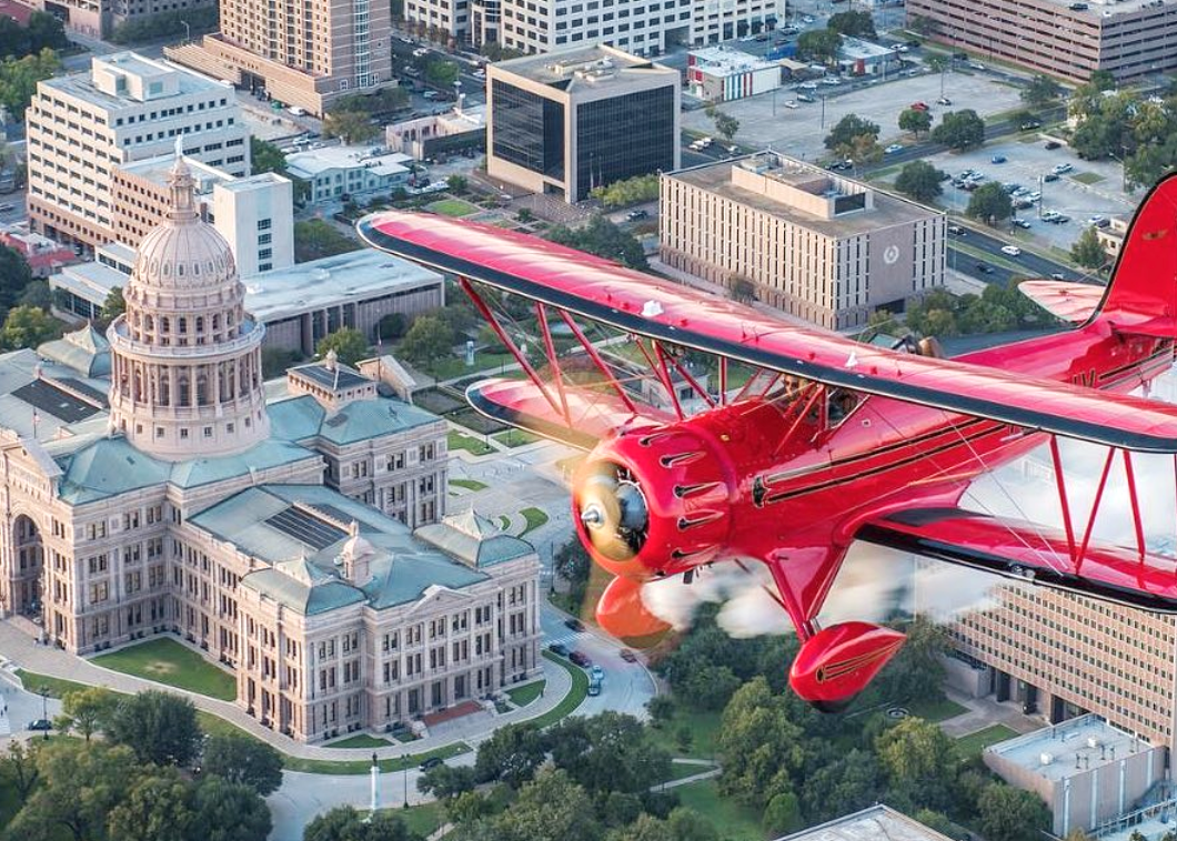 Red plane flying over Austin